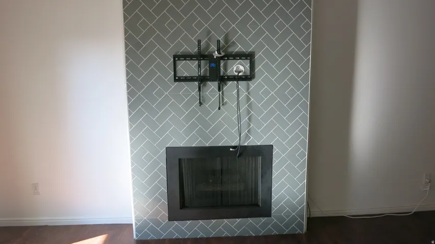 Fireplace with herringbone tile surround, dark wood-finish flooring