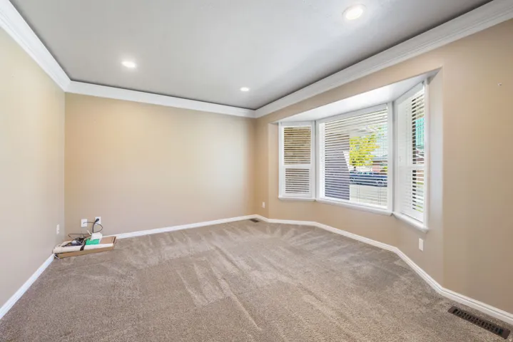 Tray ceiling, recessed lighting, crown molding, bay window, carpeted flooring