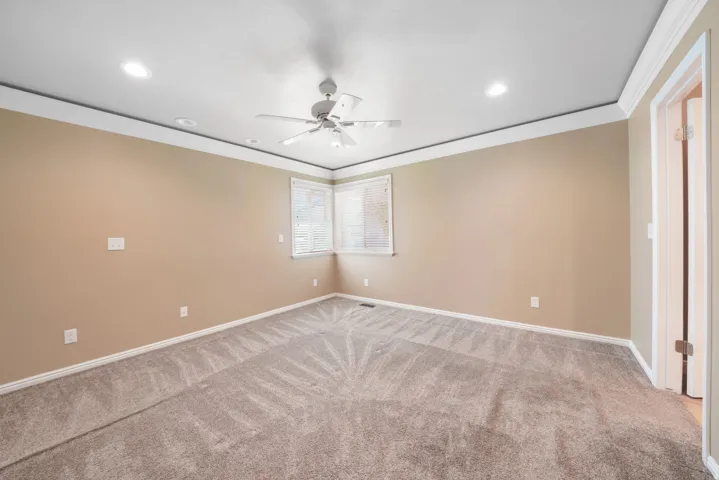 Recessed lighting, crown molding, corner windows with blinds, ceiling fan, and carpeted flooring