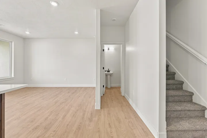 Expansive room with wood-finish flooring, recessed lighting, and a large window