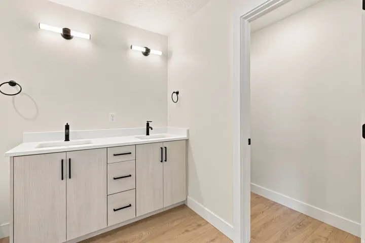 Dual vanity with white countertop, undermount sinks, and matte black fixtures