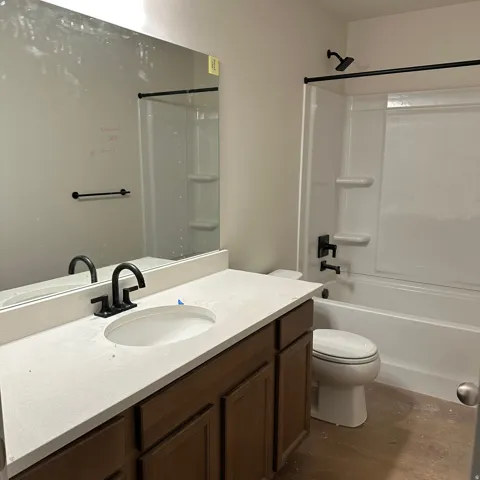 Modern bathroom with a white vanity countertop, undermount sink, and dark wood-finish cabinetry