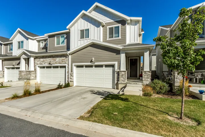 Two-story exterior with a covered porch, stone accents, and an attached two-car garage