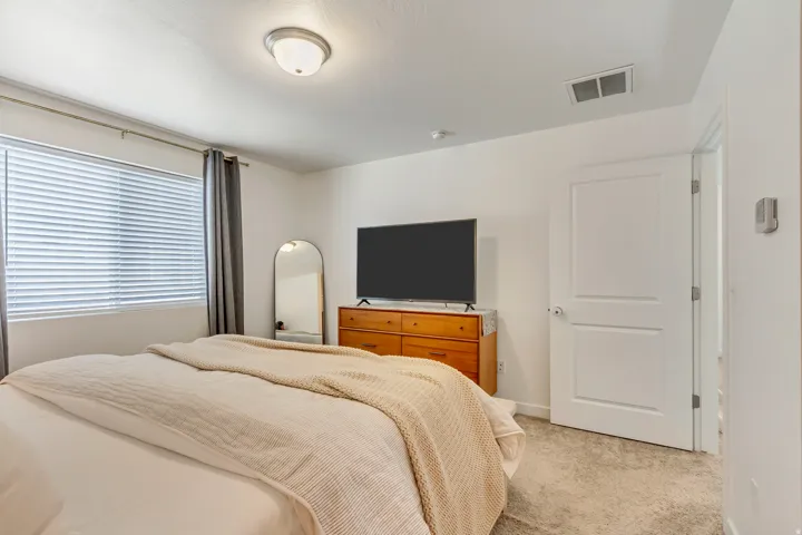 Recessed window with blinds, overhead flush mount light fixture, textured carpet flooring, and a two-panel interior door