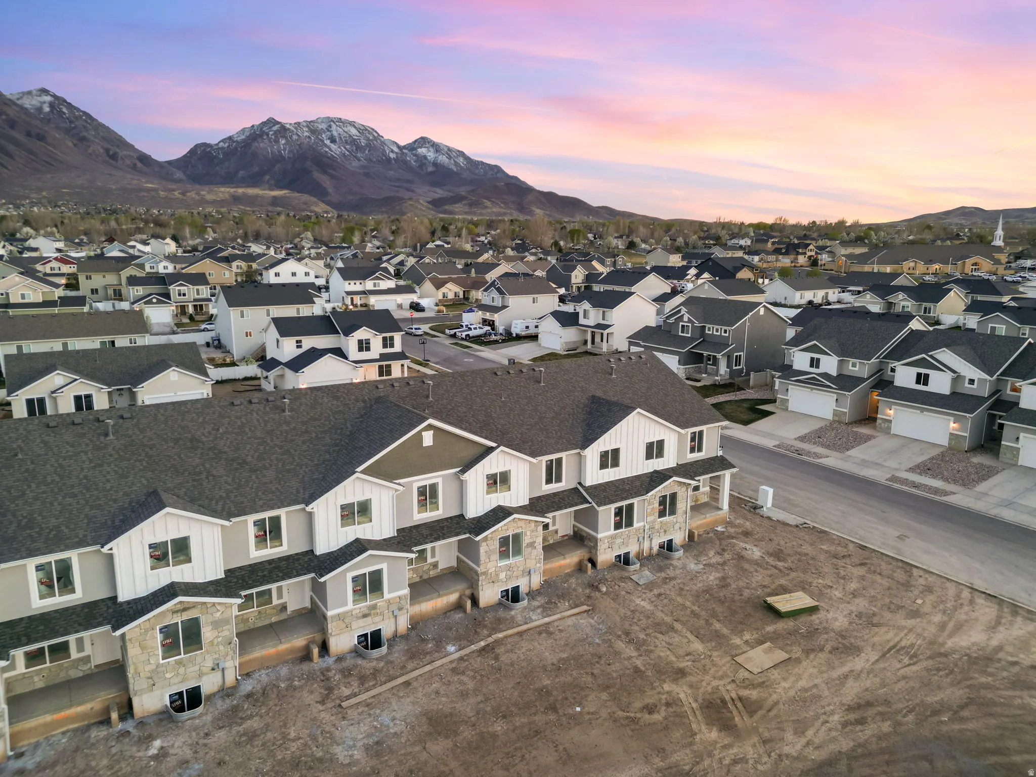 Townhome community featuring mountain scenery, a paved street, and uniform exterior finishes