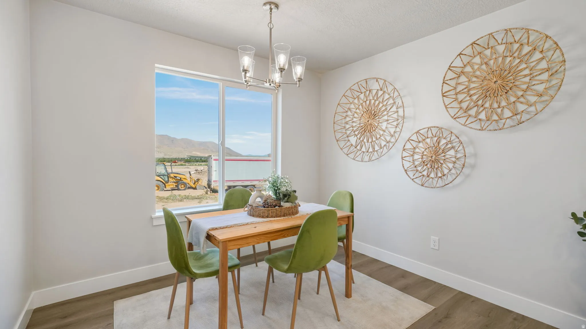 Wood-finish flooring with white baseboards, a large window, and a contemporary chandelier