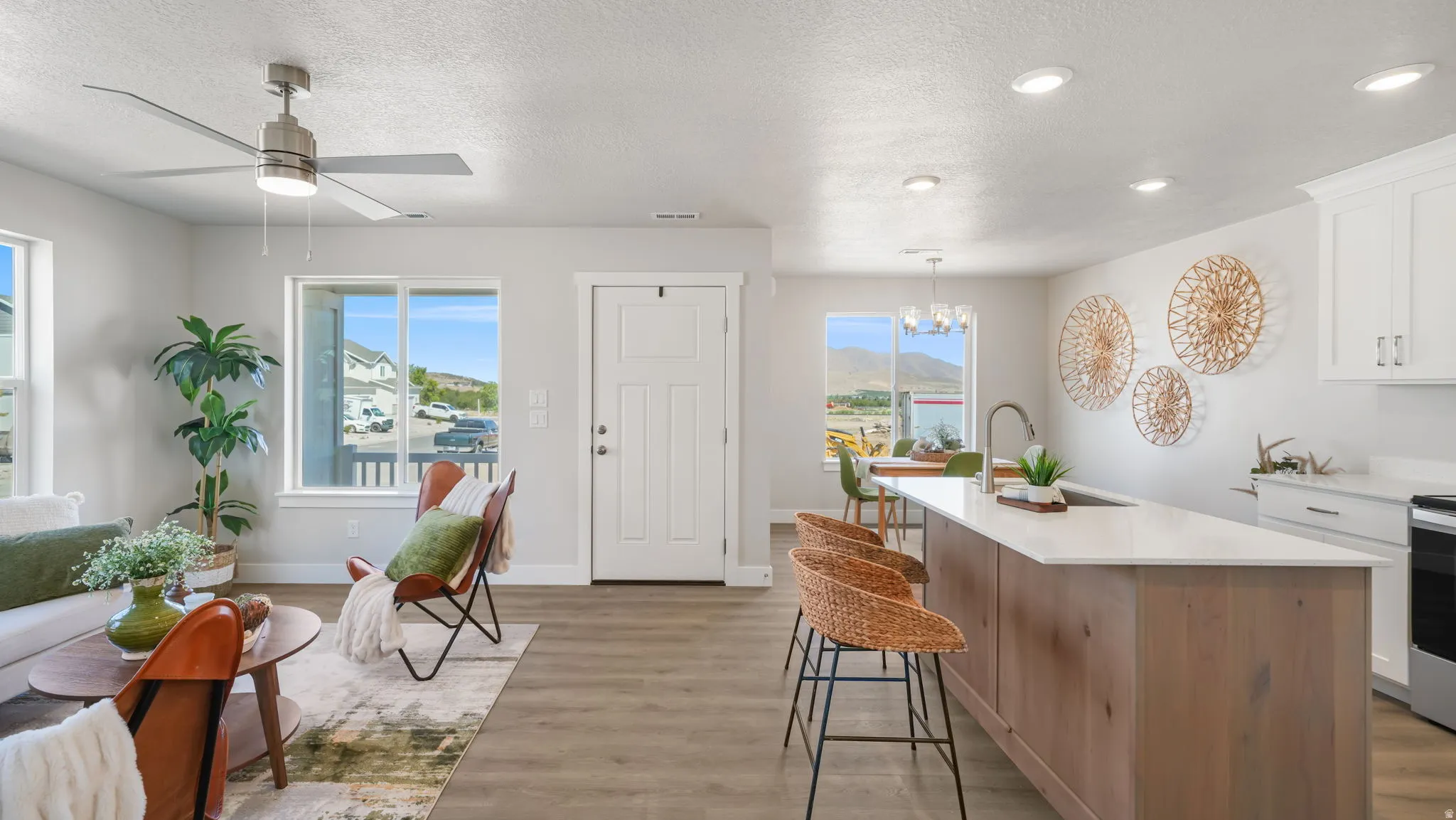 Open-concept living space with wood-finish flooring, recessed lighting, and a ceiling fan