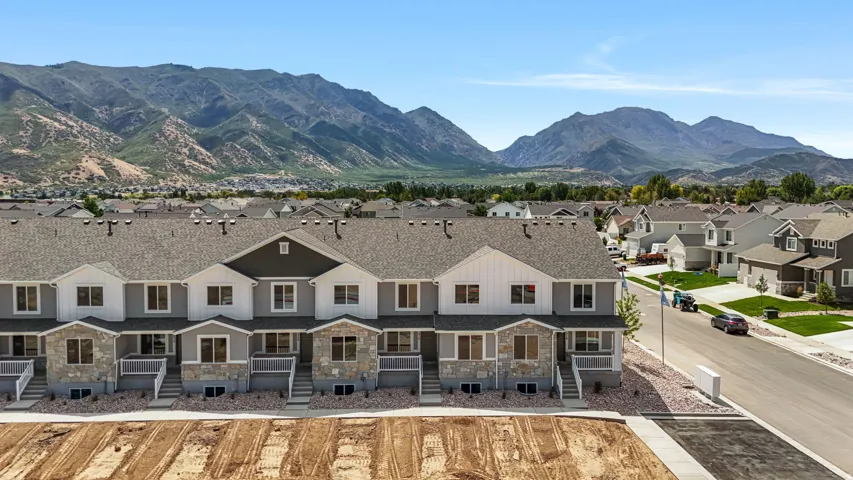 Townhome exteriors feature multi-level designs with stone veneer accents and covered entries