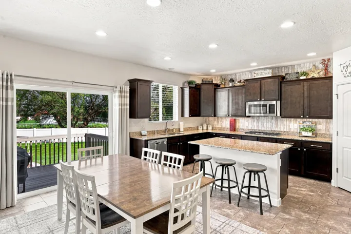 Kitchen featuring dark wood cabinetry, granite countertops, and a center island with bar seating