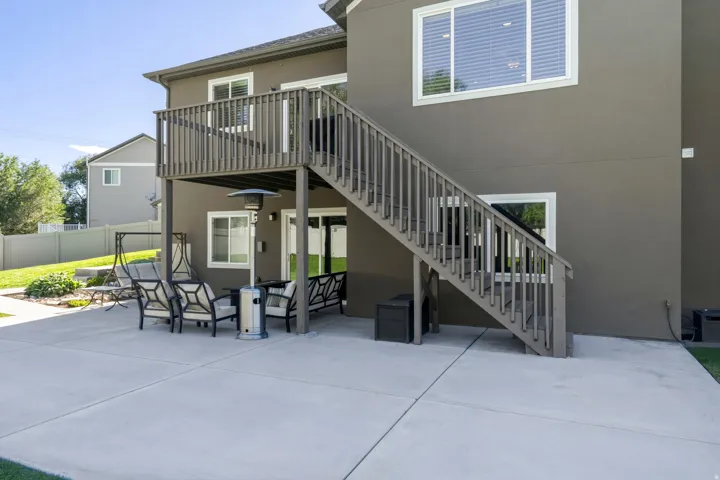 Expansive concrete patio with a full-height deck and stairs