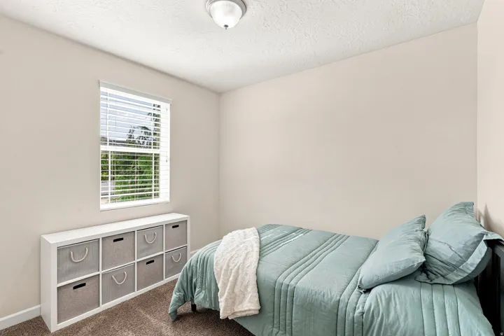 Neutral tone wall paint, window with blinds, and textured ceiling