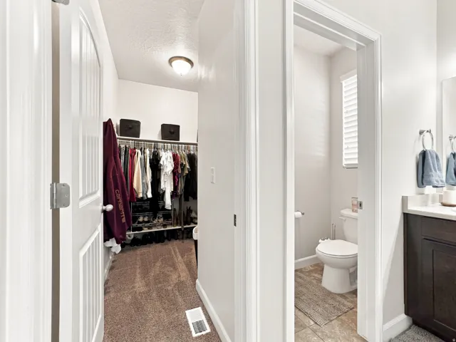 Walk-in closet with built-in shelving, white paneled doors, and ceiling-mounted lighting