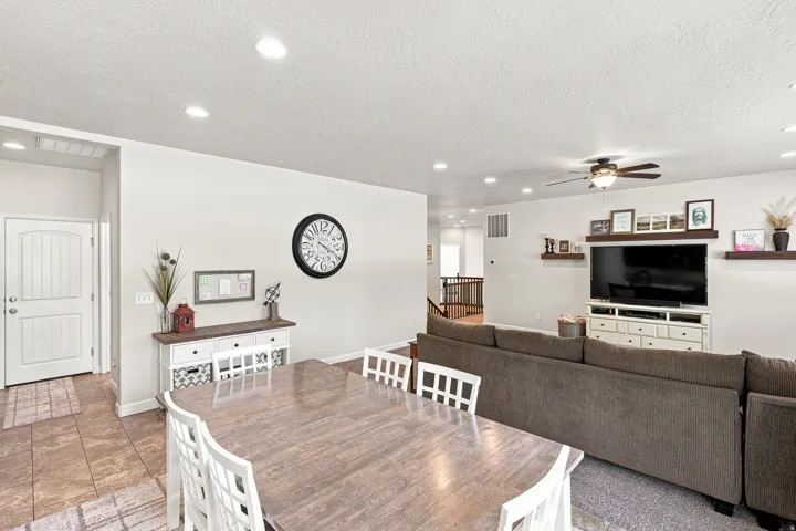 Open-concept living area with recessed lighting, a ceiling fan, and built-in shelving units