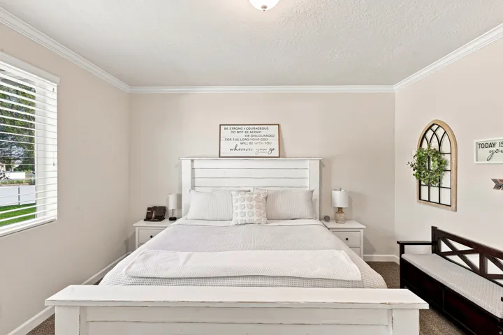 Crown molding accents the ceiling in this carpeted room