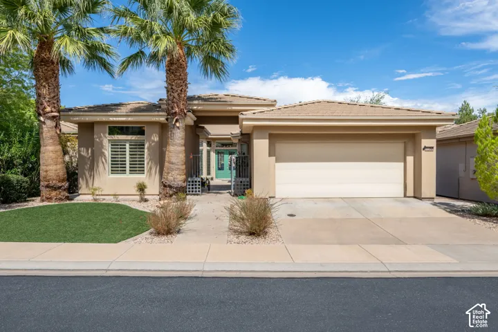 Stucco exterior with a tiled roof, an integrated two-car garage, and a concrete driveway