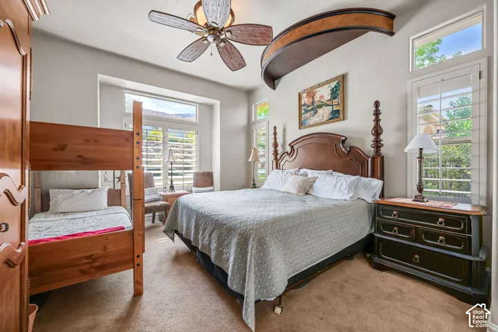 Recessed windows with plantation shutters, ceiling fan, and built-in architectural ceiling detail