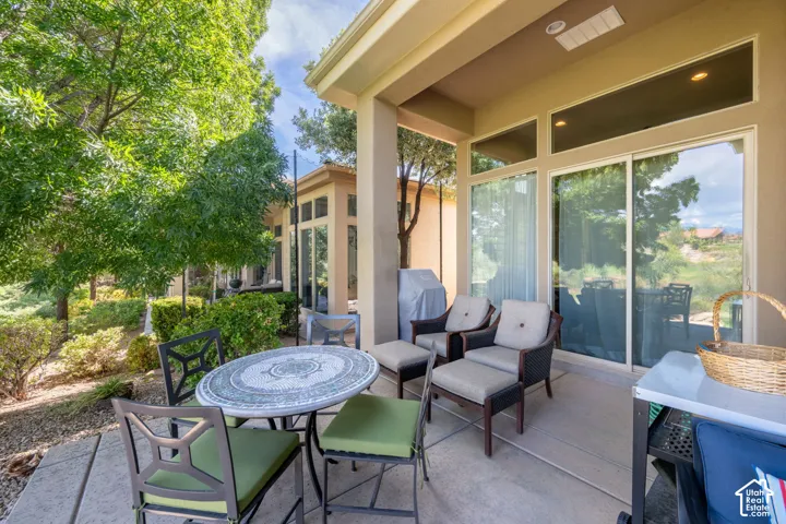 Covered patio with concrete flooring, multiple sliding glass doors, and recessed lighting