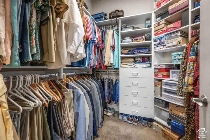 Walk-in closet with built-in shelving, multiple hanging rods, and integrated drawers