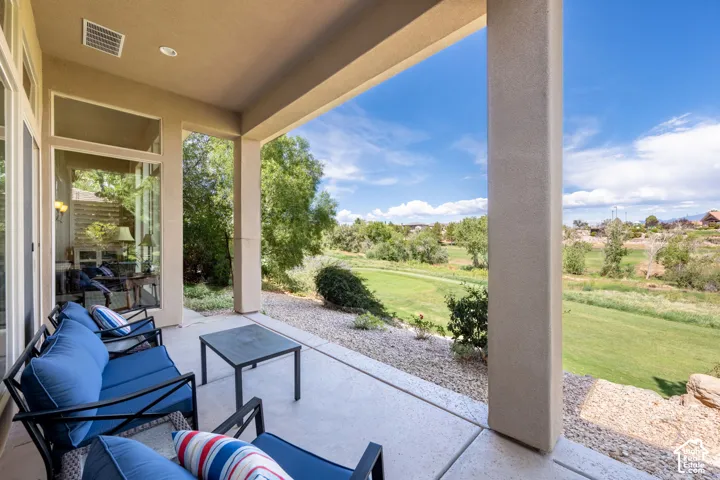 Covered patio with concrete flooring, stucco pillars, and a gravel perimeter