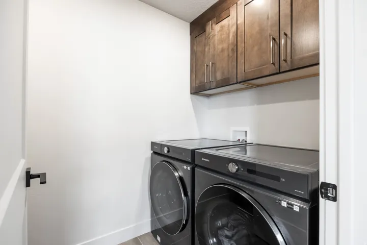 Laundry area with dark wood-finish cabinetry and white walls