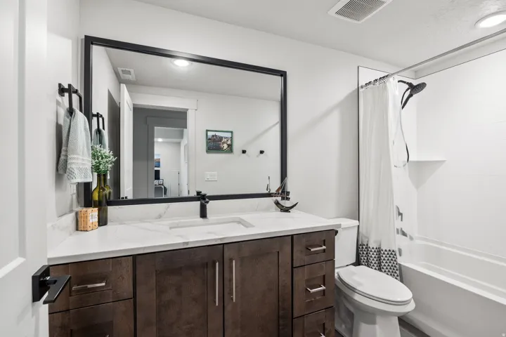Dark wood-finish vanity with a white countertop and integrated sink