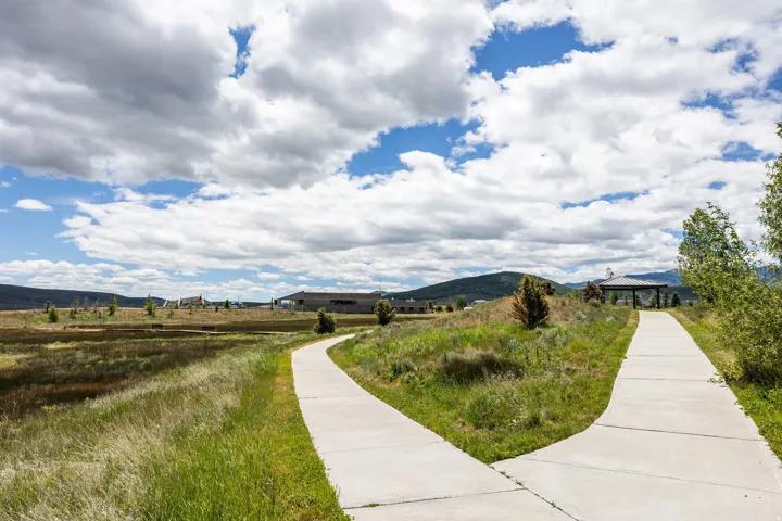 Paved walking paths featuring a fork, surrounded by natural landscaping and distant architectural structures