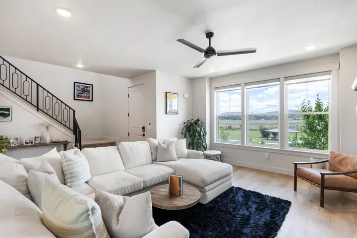 Bright living space featuring wood-finish flooring, a contemporary ceiling fan, and recessed lighting
