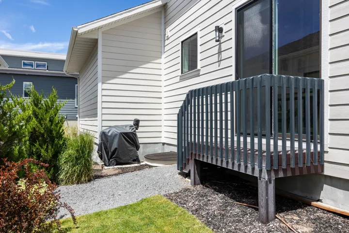 Sliding glass door leading to a wood deck with dark railing