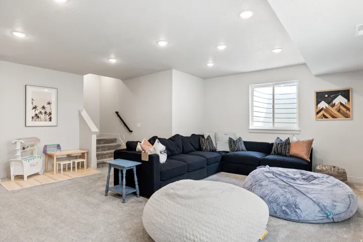 Recessed lighting, carpeted flooring, staircase with white railing, white walls, and a window with blinds