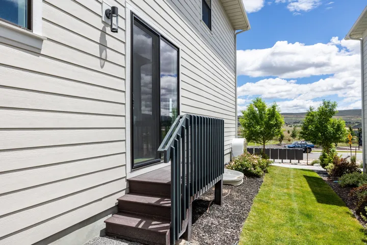 White horizontal siding with black-framed sliding glass door