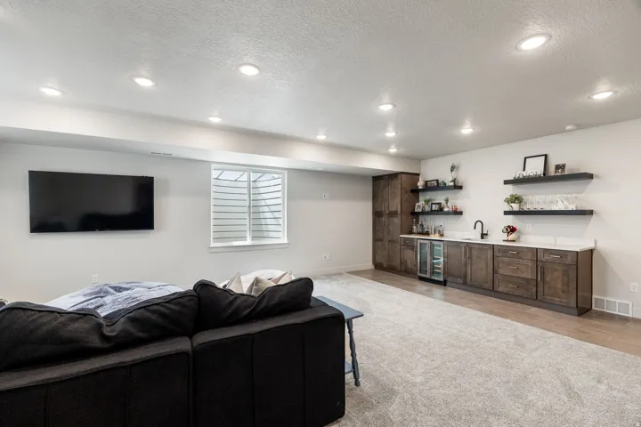 Recessed lighting, wood-finish flooring, built-in cabinetry, beverage refrigerator, and a sink with a black-finish faucet