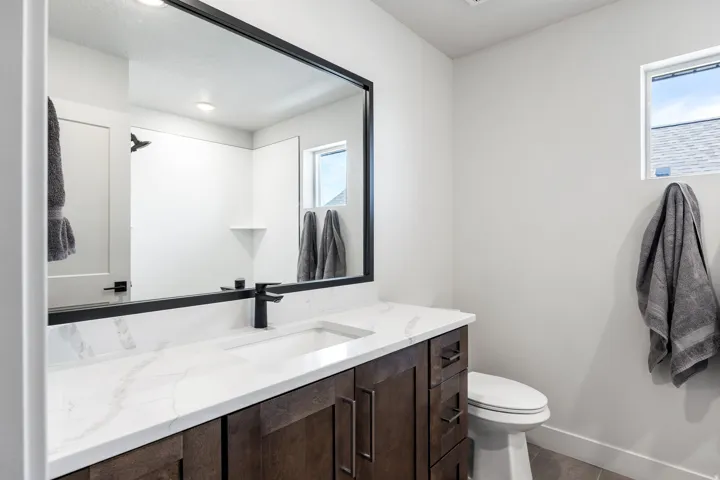 Dark wood-finish vanity with a white countertop and integrated sink