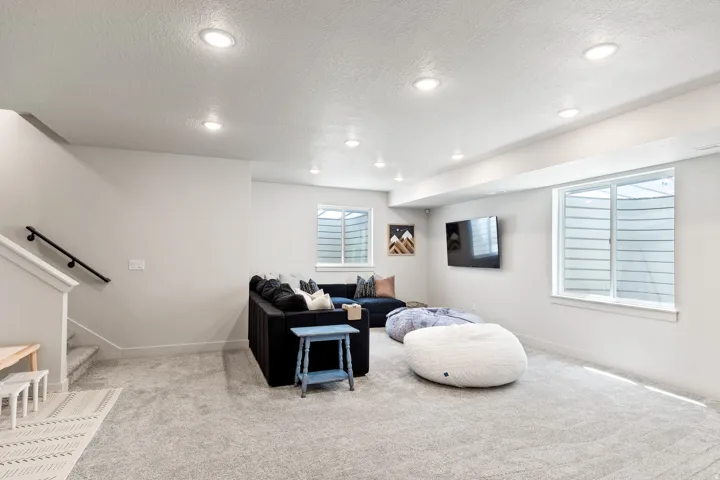 Recessed ceiling lighting, two windows with window wells, and light gray wall-to-wall carpeting