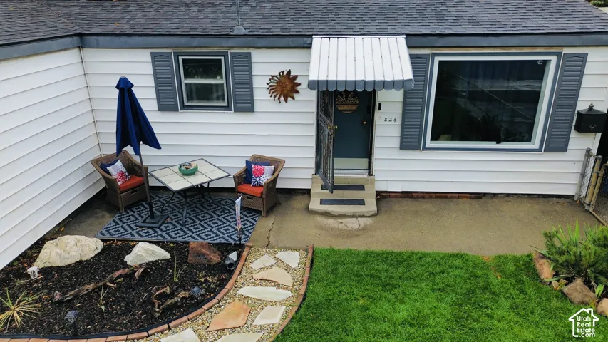 White horizontal siding exterior with contrasting gray trim, a prominent entry awning, and a stone path leading to a manicured lawn