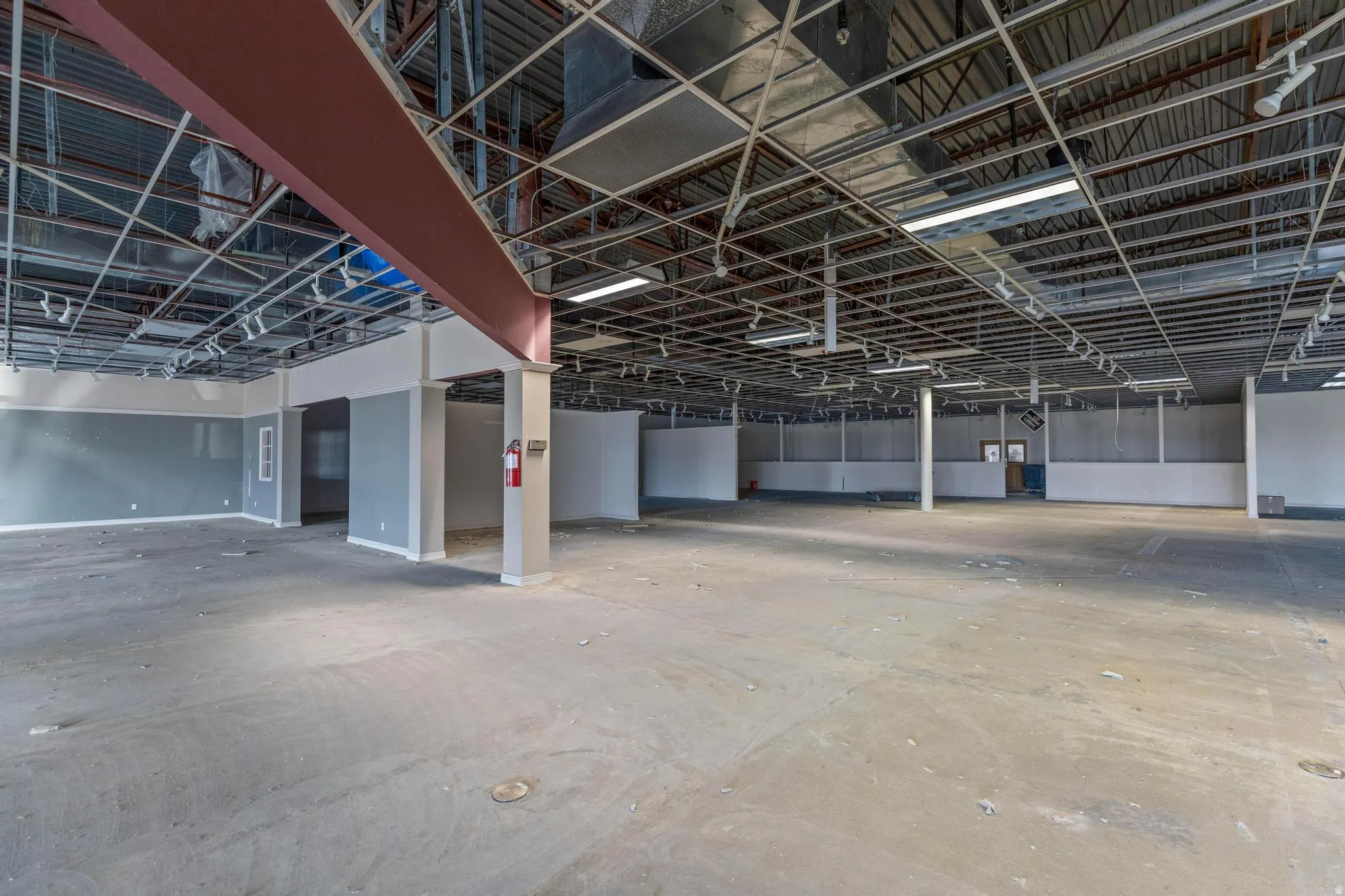 Expansive open-concept concrete floor space with exposed ceiling infrastructure