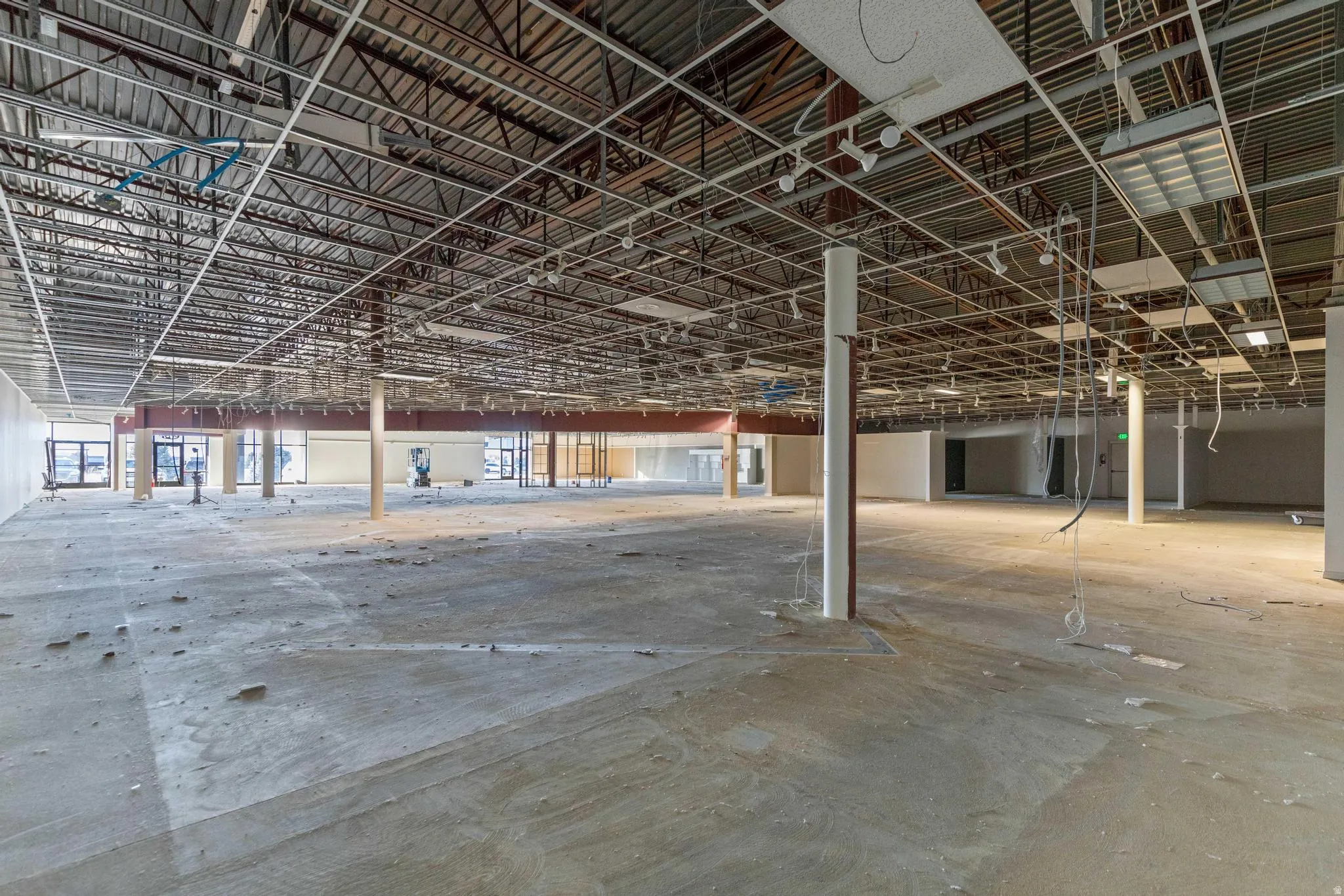 Expansive open layout with exposed ceiling trusses and concrete flooring