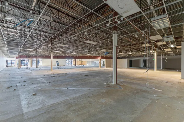 Expansive open layout with exposed ceiling trusses and concrete flooring