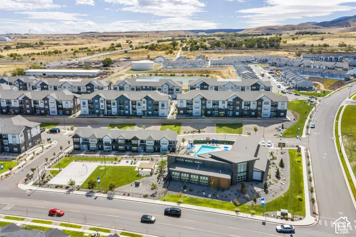 Community grounds with multiple residential buildings, a rectangular swimming pool, and a recreational court
