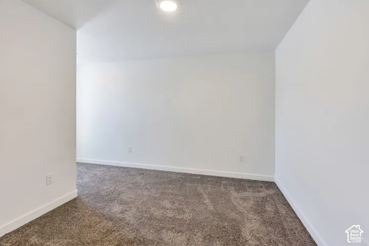 Plush carpeting, bright white walls, recessed ceiling lighting, and crisp white baseboards
