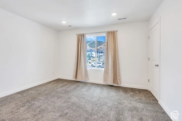 Neutral wall color with recessed lighting and a window featuring mountain scenery