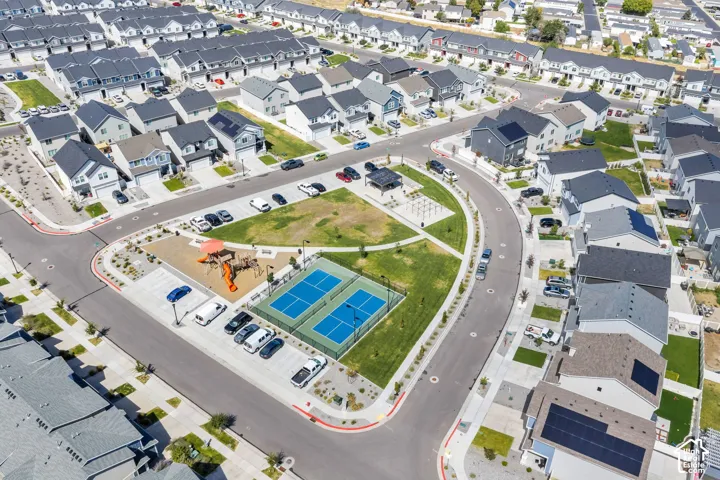 Community green space featuring two tennis courts, playground, and shaded seating area