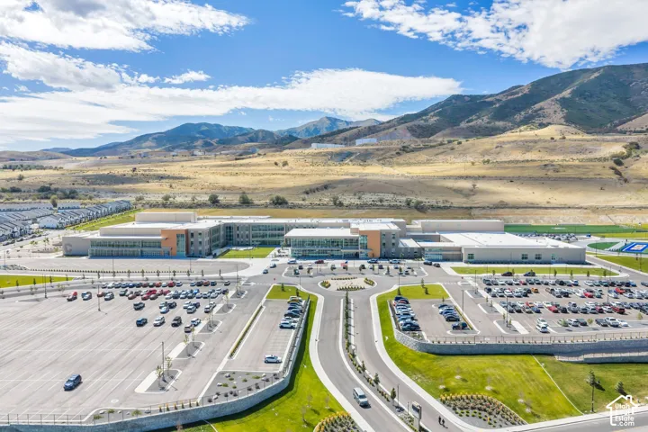 Expansive property featuring a modern multi-building complex, multiple large parking areas, and surrounding manicured green spaces