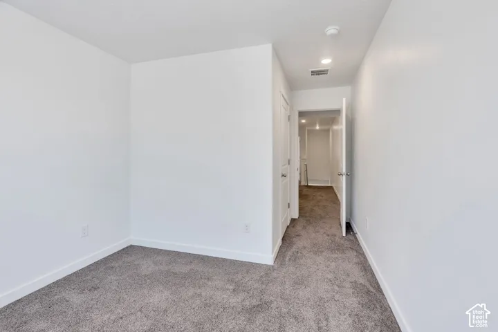 Neutral wall paint, carpet flooring, recessed lighting, and white trim
