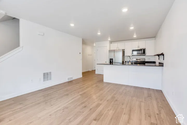 Open concept living area with wood-finish flooring