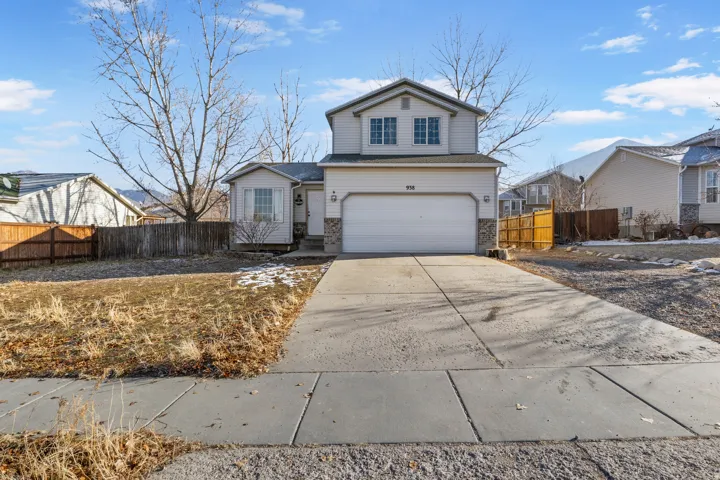 Two-story residence with a two-car garage, stone accents, and a concrete driveway