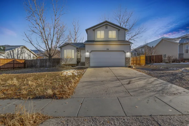 Two-story exterior with siding, attached two-car garage, stone accents, and a concrete driveway