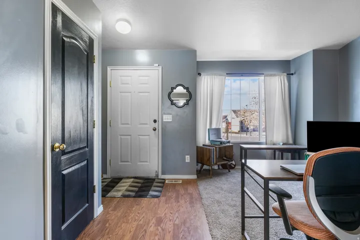 Entryway featuring wood-finish flooring, a paneled front door, and a paneled interior door with brass hardware