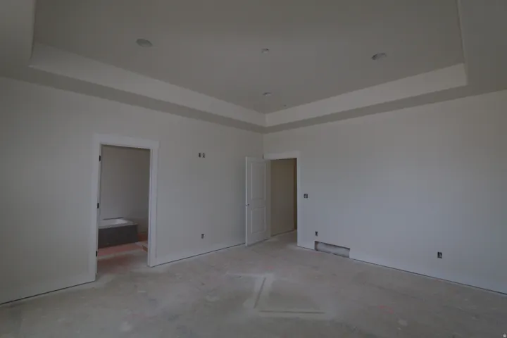 Tray ceiling with recessed lighting, white trim around doorways