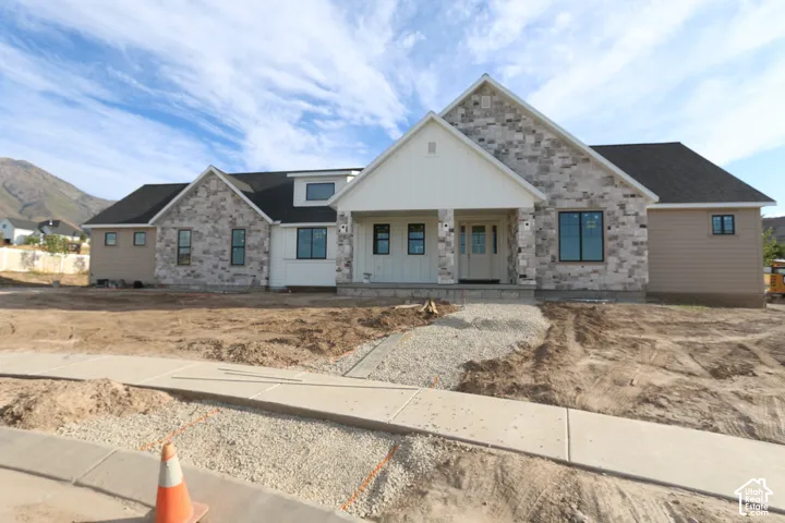 Stone veneer and horizontal siding exterior with a dark shingle roof