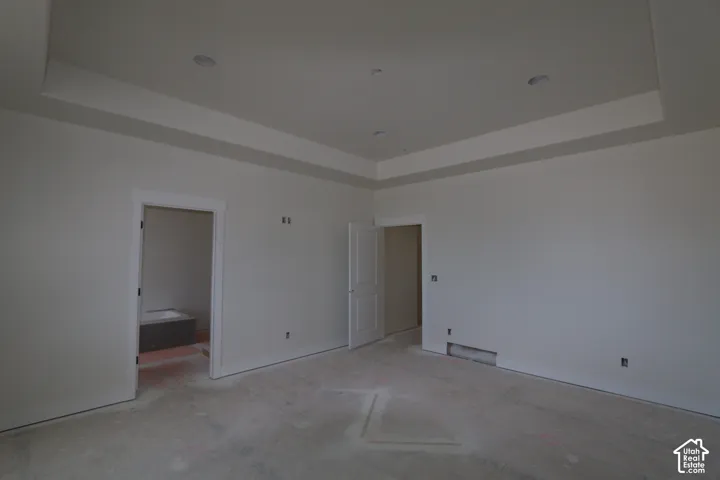 Tray ceiling with recessed lighting, white trim around doorways